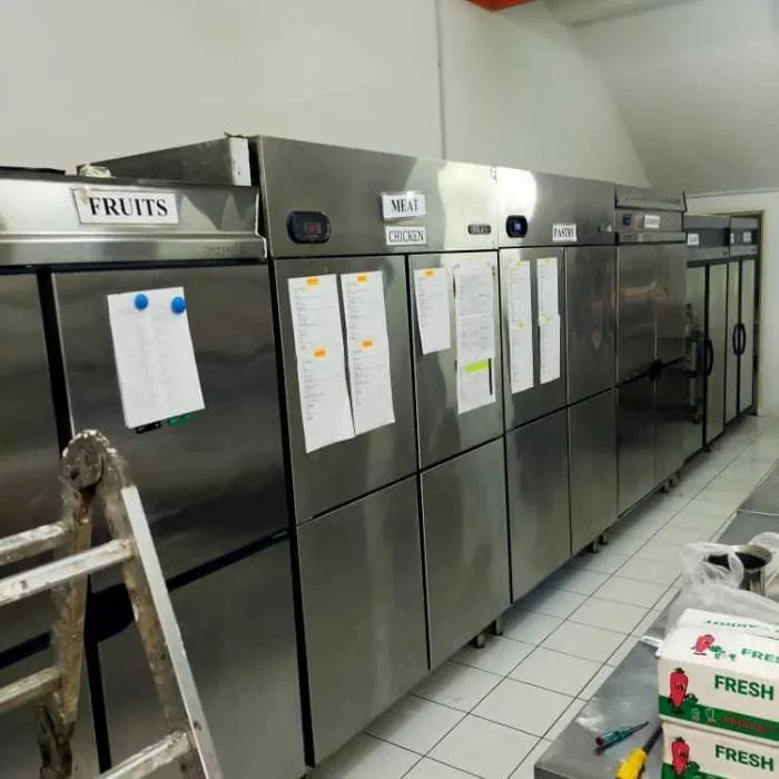 Technician servicing a stainless steel upright freezer